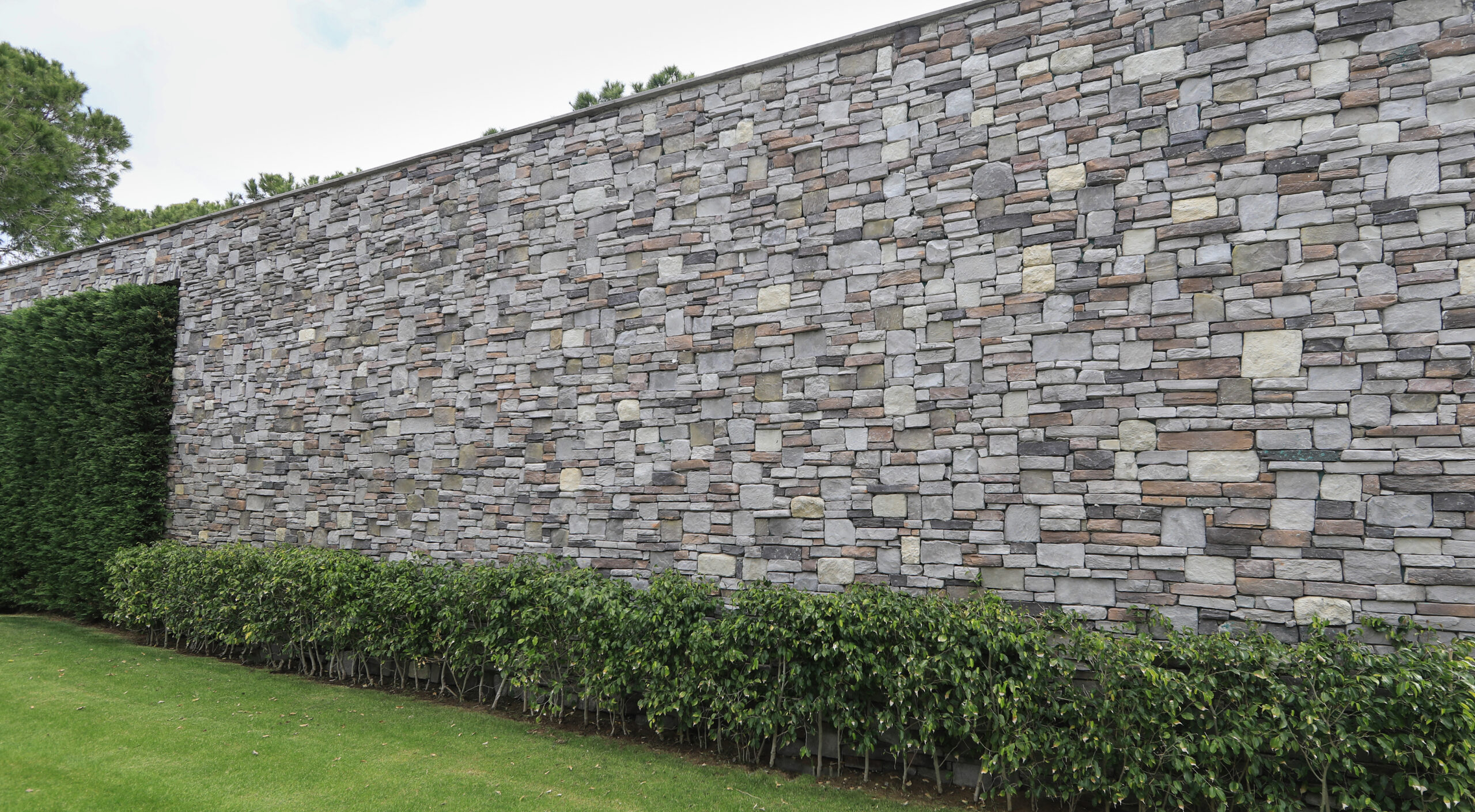 pared-de-piedra-gris-de-fondo-y-espacios-verdes