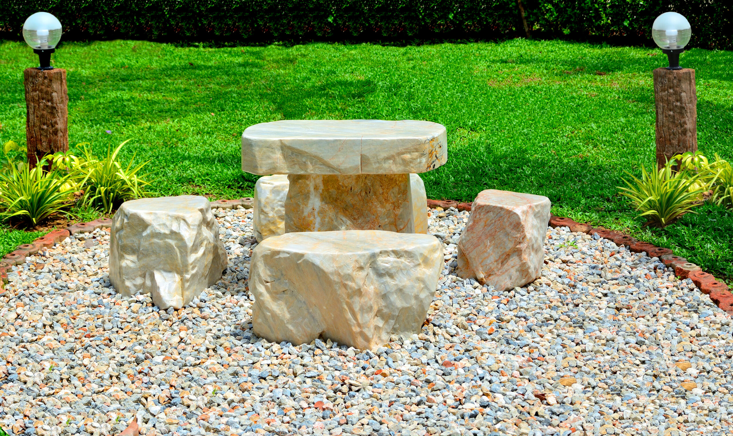 Marble chair on pebbles in garden have grass  background.